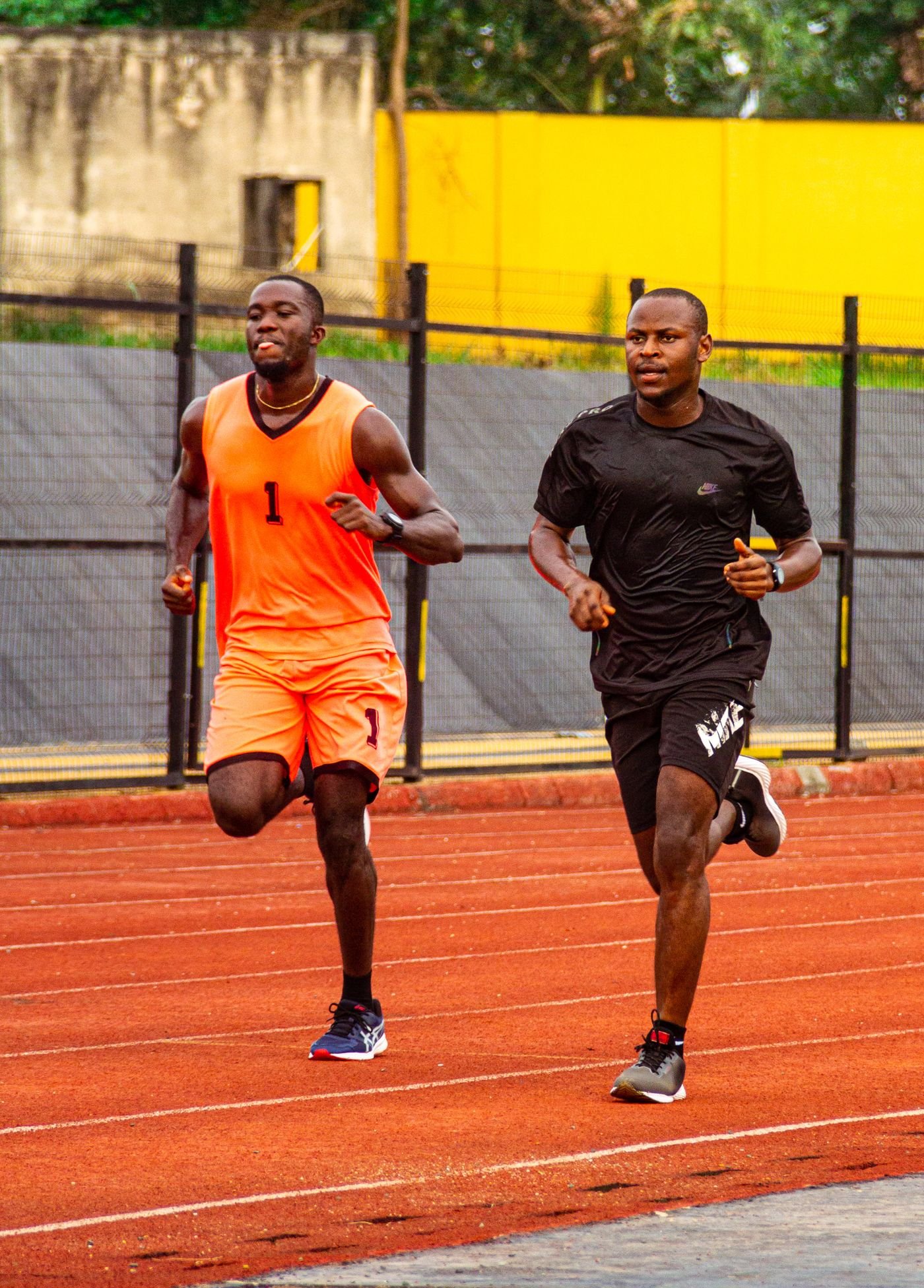 Two sprinters training together on an outdoor running track