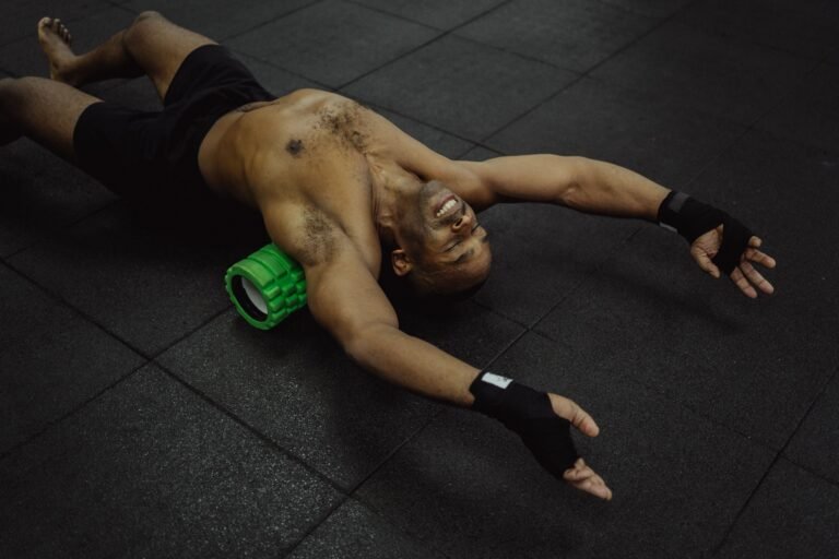 Man using a foam roller under his back in a gym