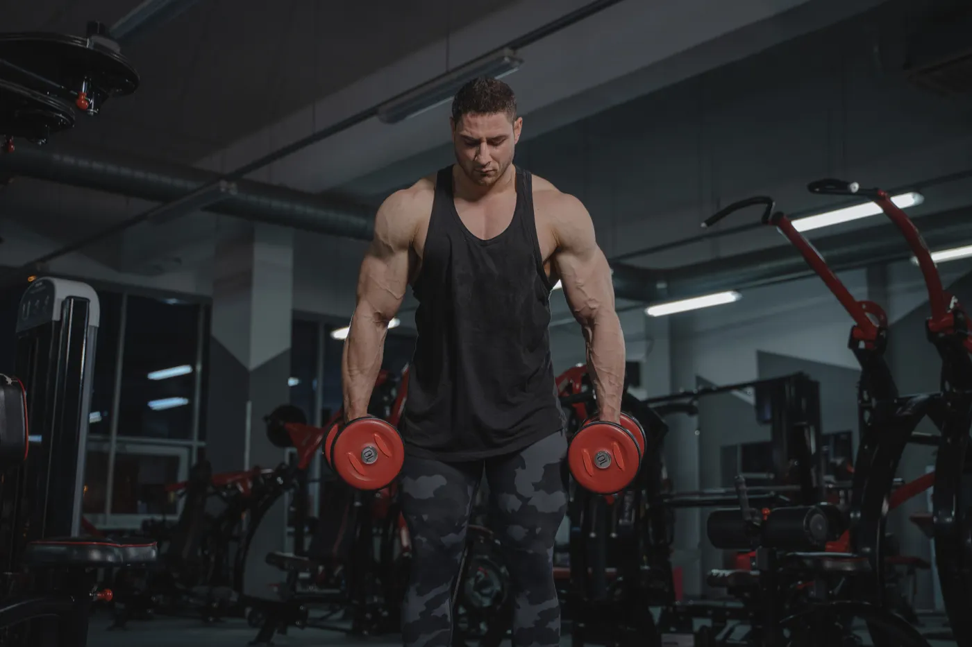 Athlete performing a dumbbell strength exercise in a gym