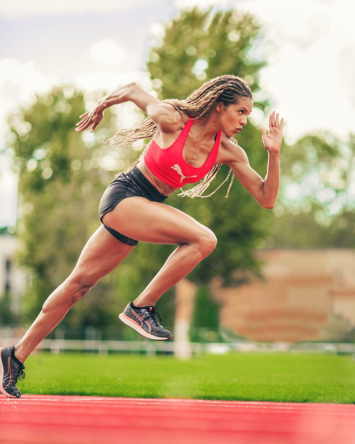 Female sprinter accelerating on an athletics track