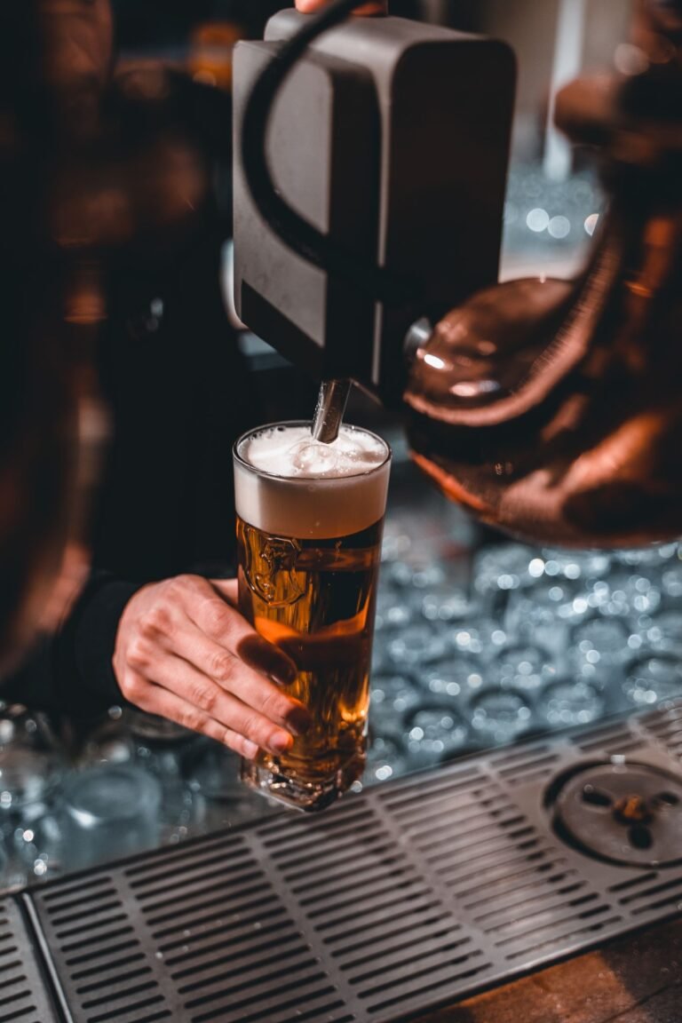 Glass of beer being poured from a tap, illustrating alcohol and post-workout recovery