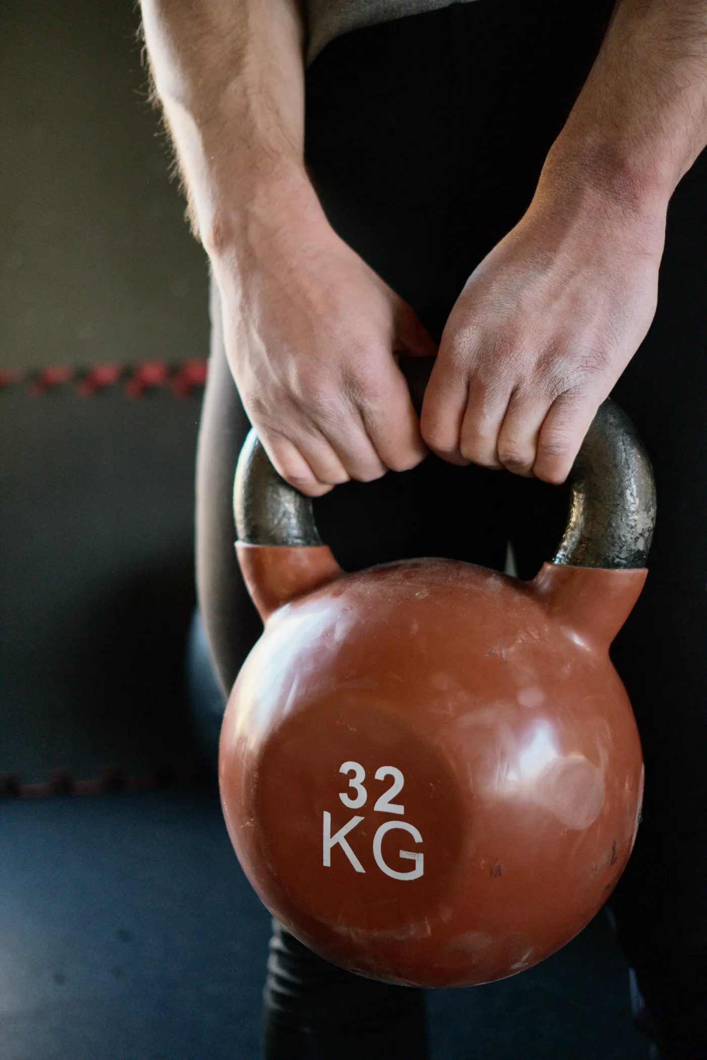 Hands holding a kettlebell by its handle