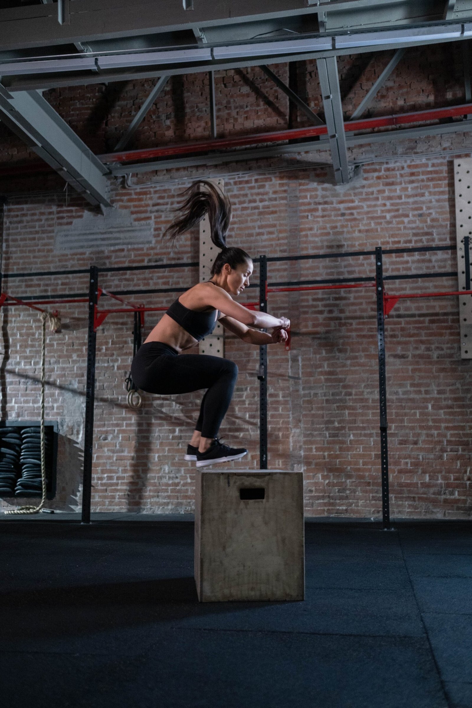 Woman landing on a plyometric box during jump training