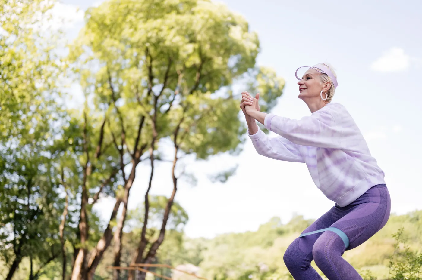 Older woman exercising with a resistance band outdoors