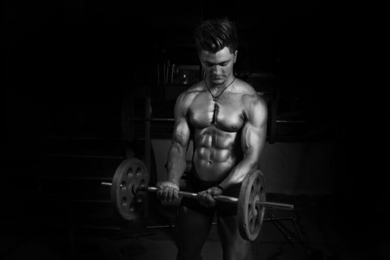 Athlete lifting a barbell in a dark gym