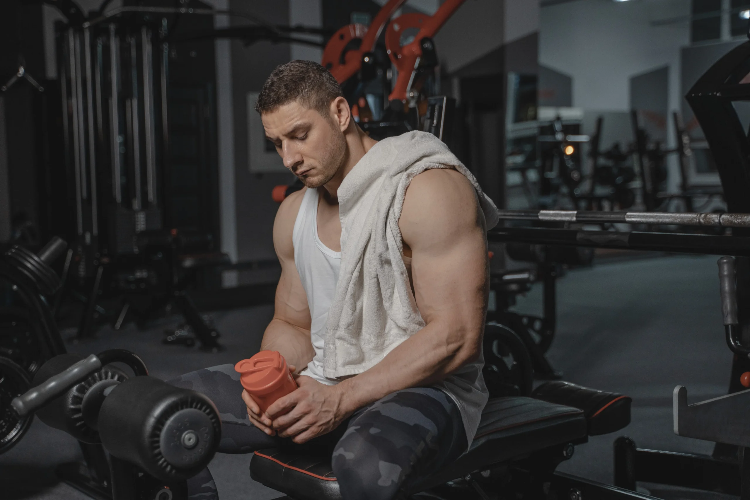 Lifter seated after training holding a shaker bottle