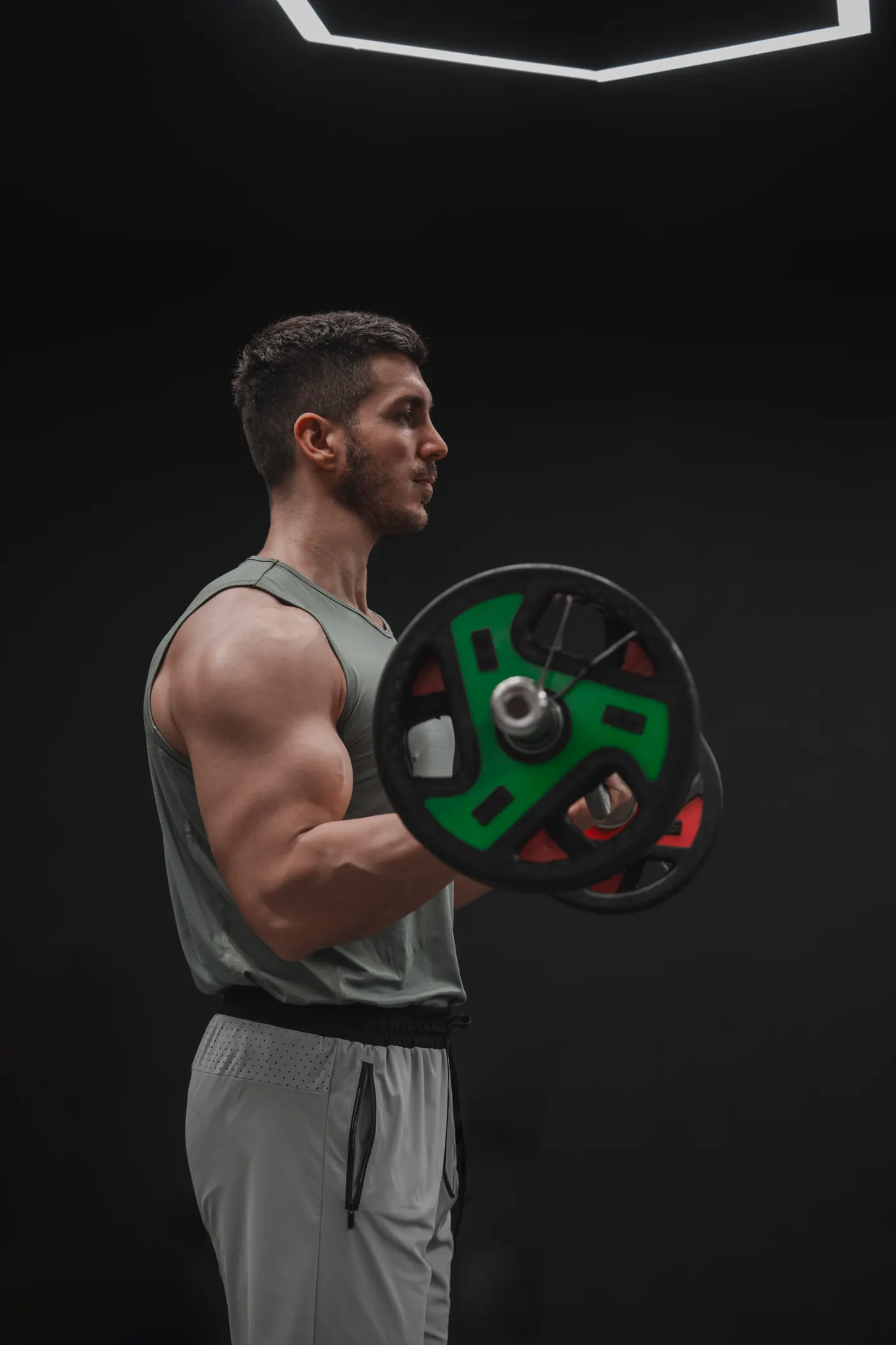 Athlete lifting a barbell in a dimly lit strength gym