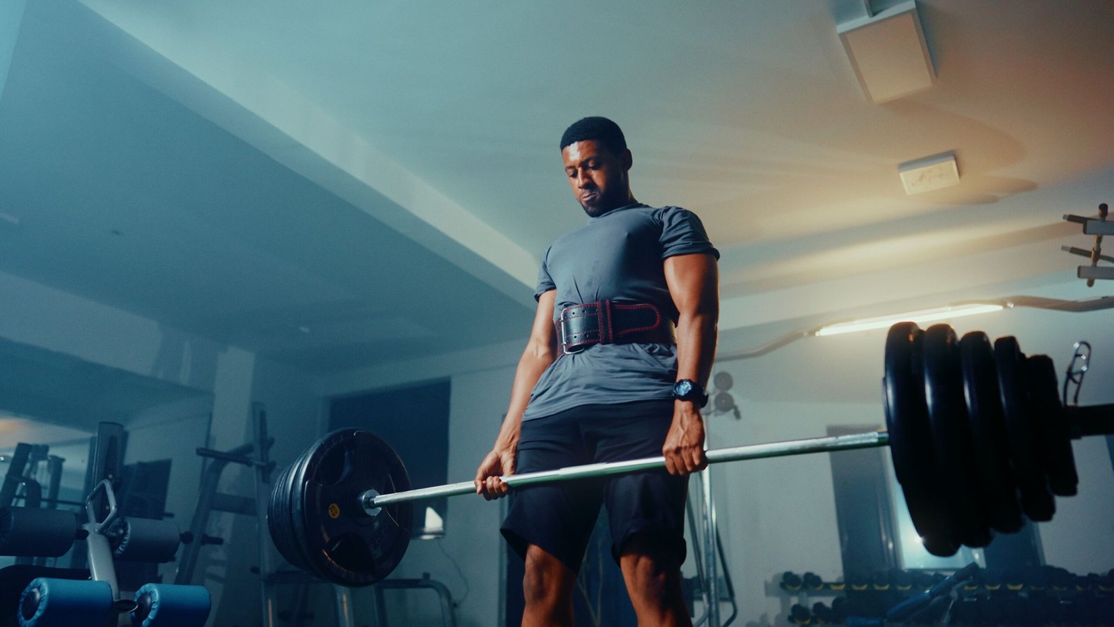 Athlete completing a heavy barbell deadlift in a gym