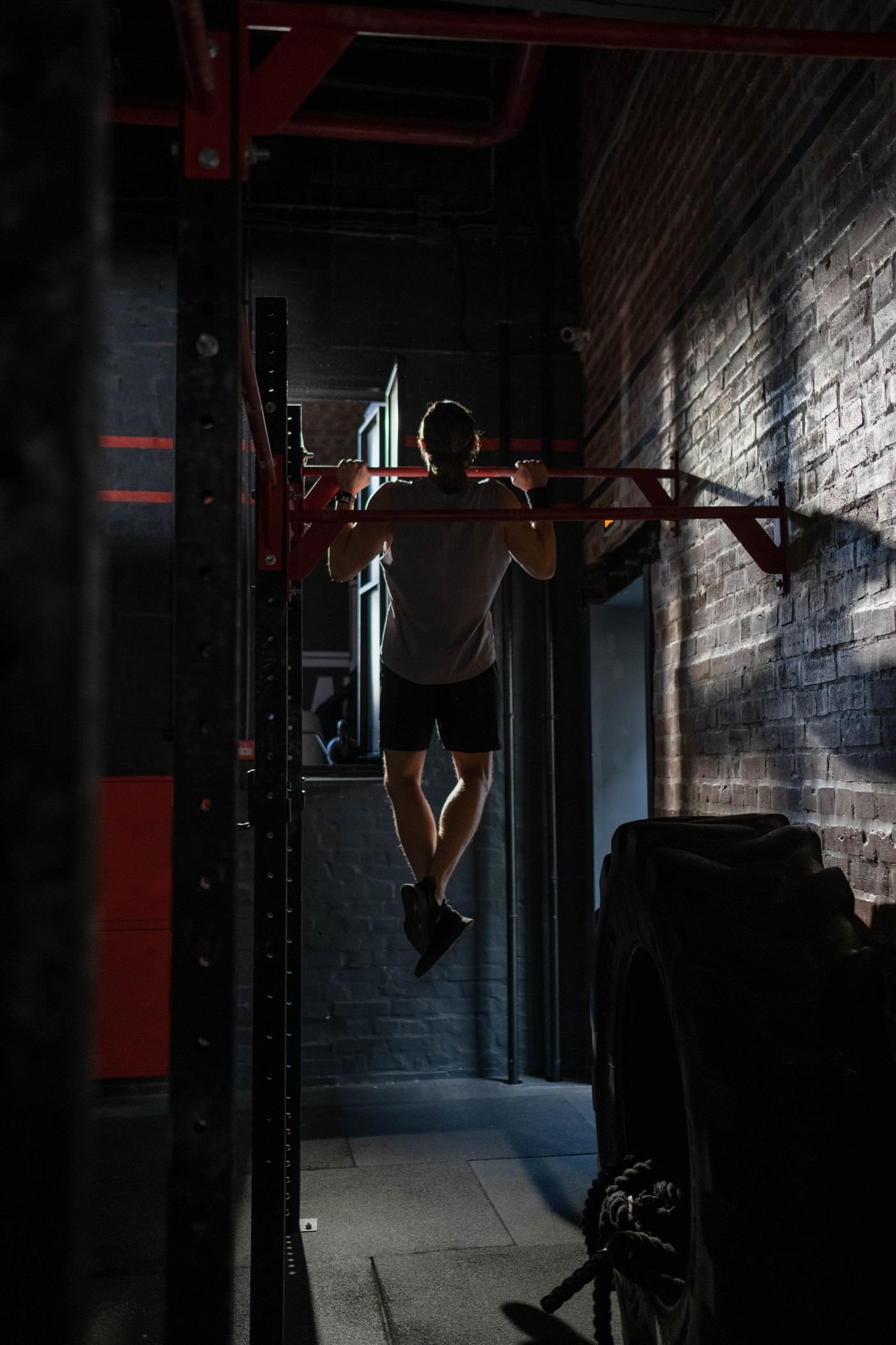 Man completing pull-ups during an indoor strength workout