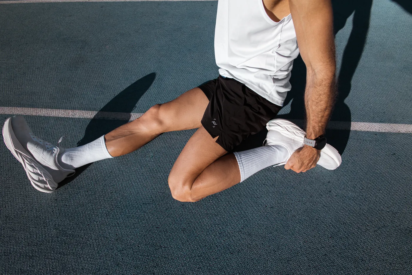 Runner stretching on an outdoor track before training