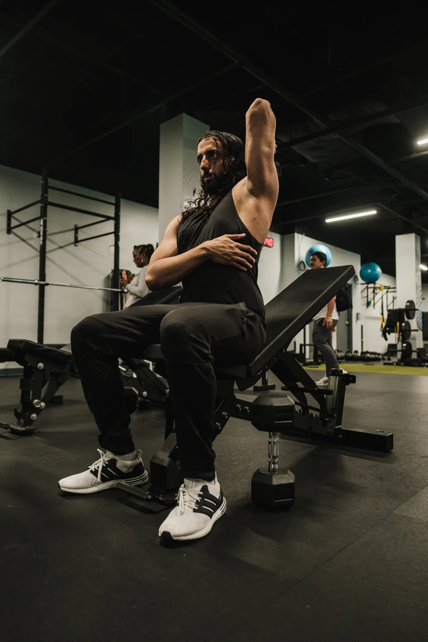 Man seated on a weight bench during an upper-body training session