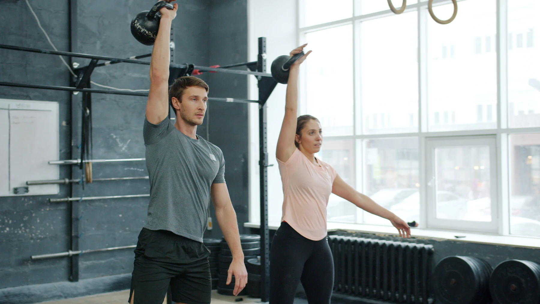 Two athletes holding kettlebells during a strength workout