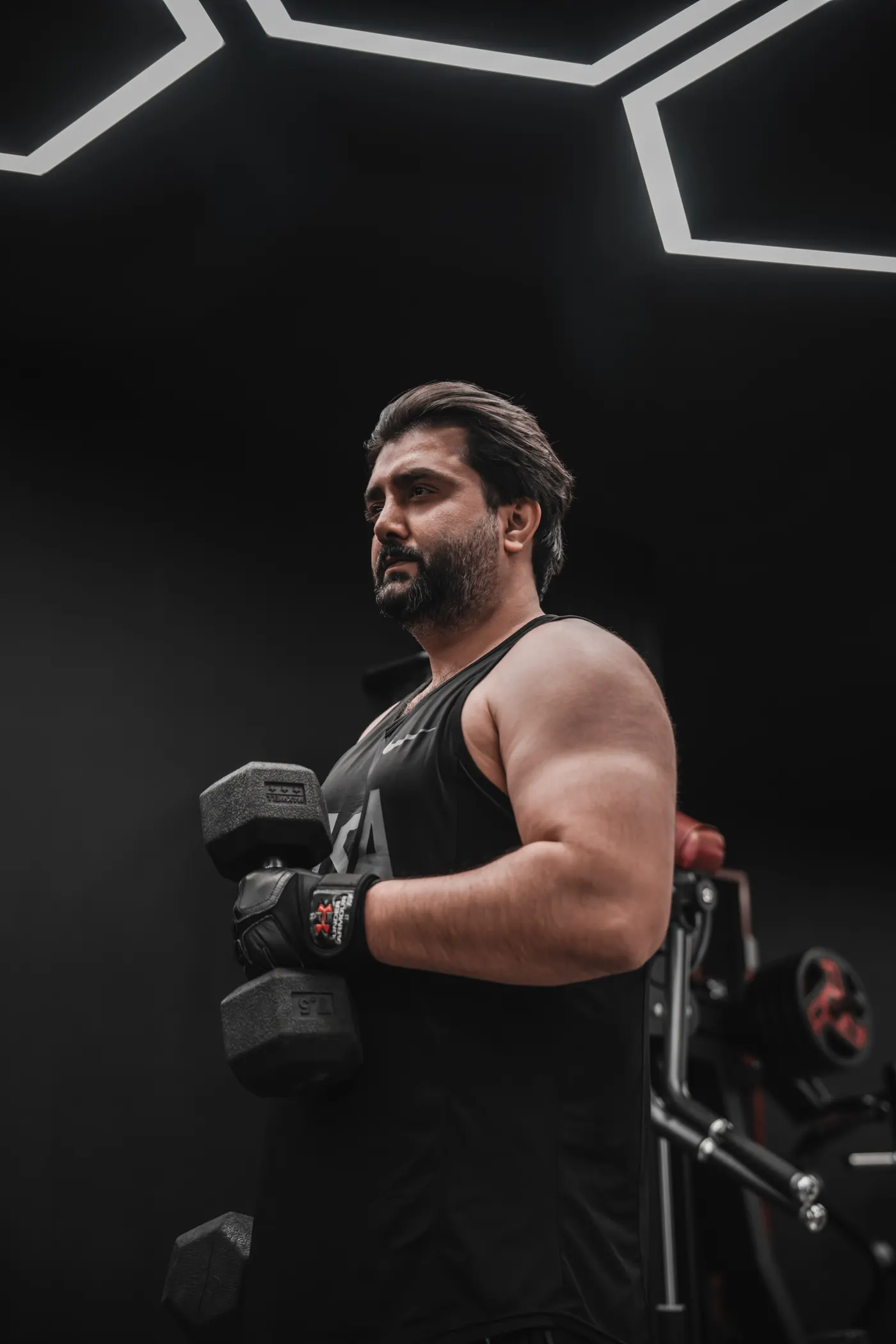 Man lifting a challenging dumbbell in a modern gym