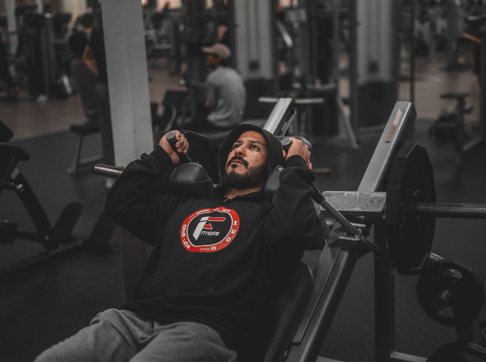 Man pressing weights on a bench in a modern gym