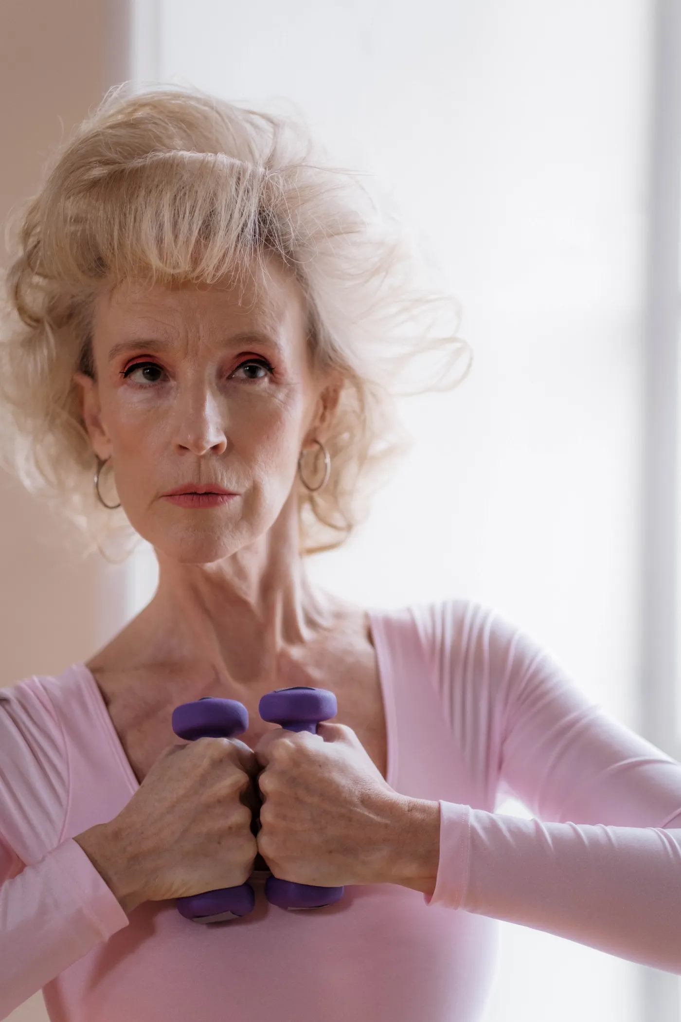Older woman holding dumbbells during an indoor strength session