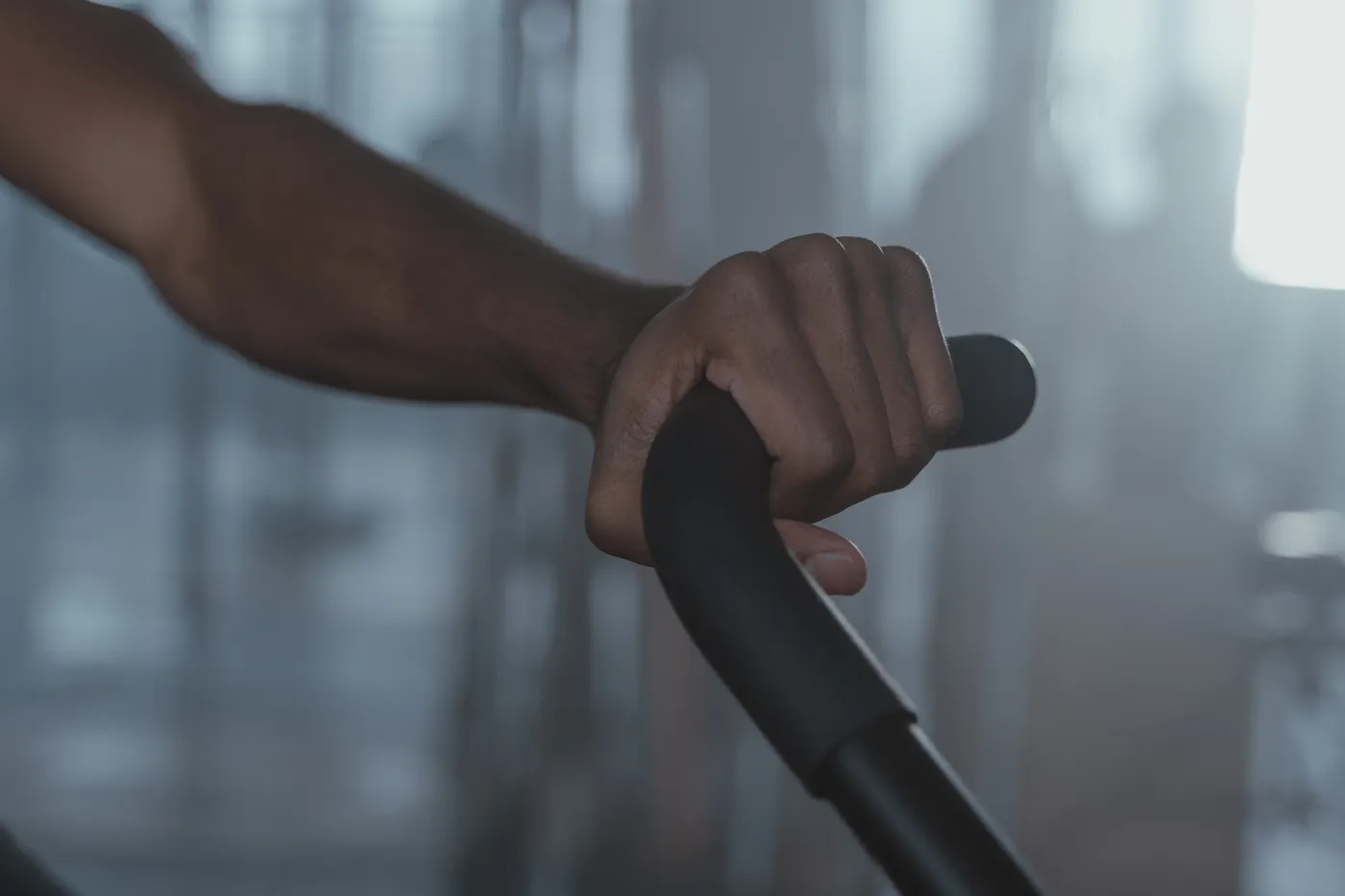 Hand gripping a rope attachment on gym equipment
