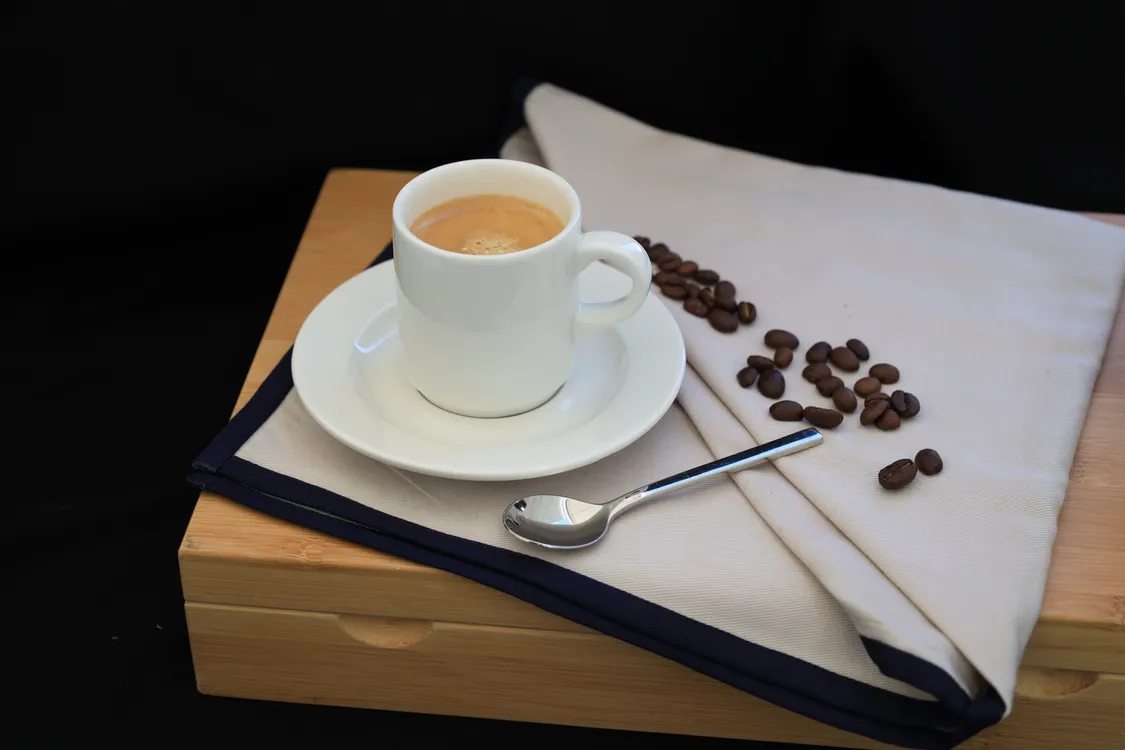 Espresso cup and coffee beans illustrating a caffeine dose