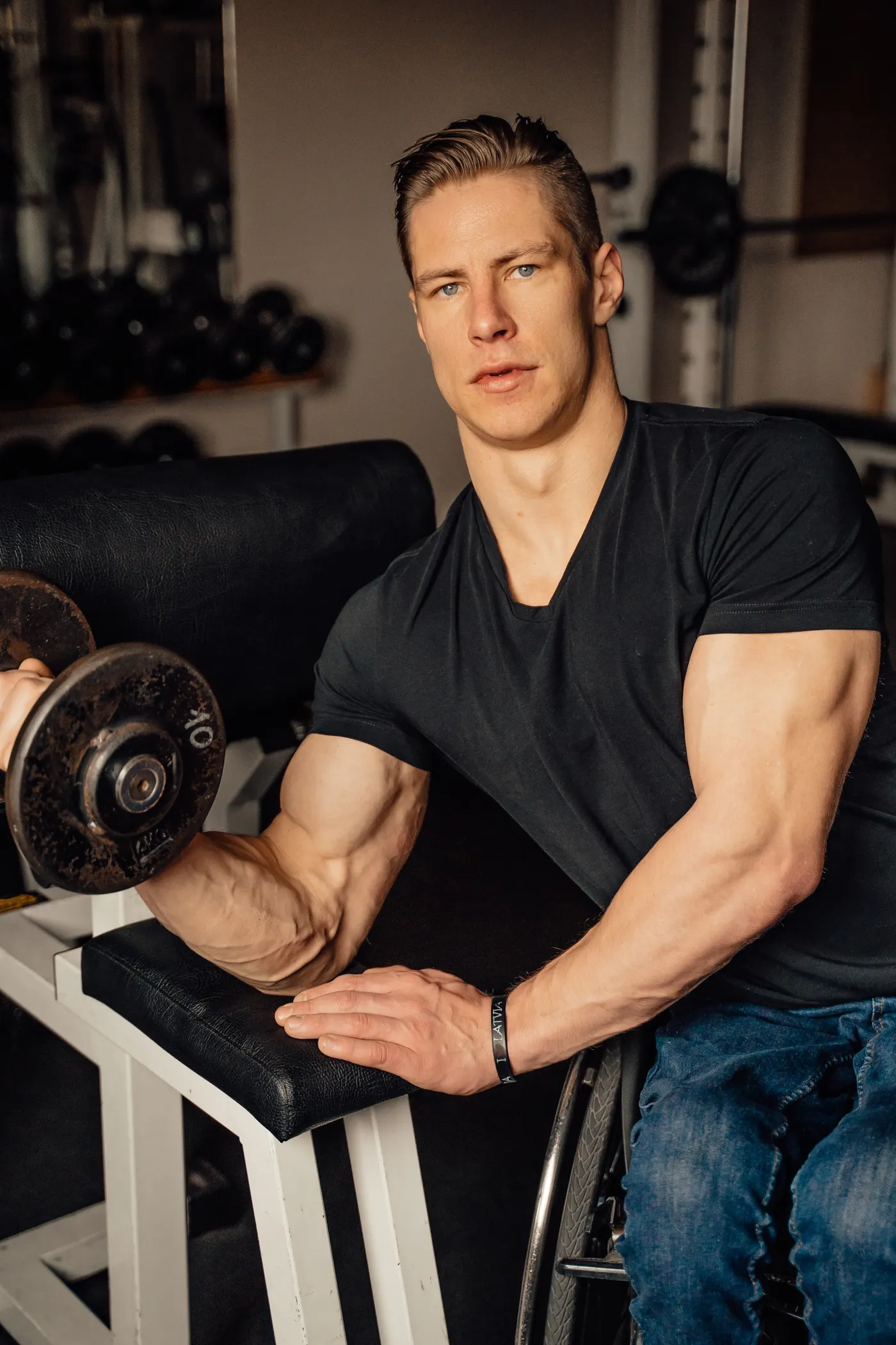 Man performing a controlled dumbbell curl in a gym