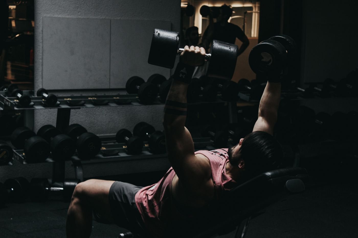 Man performing dumbbell bench presses during a resistance-training session