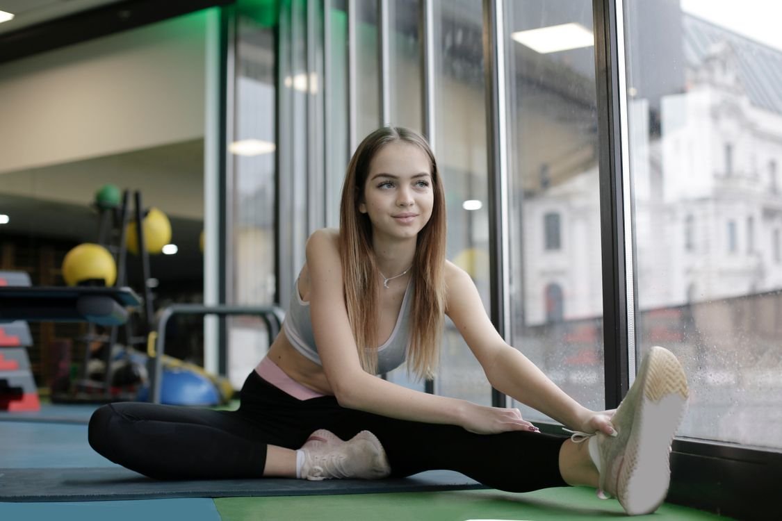 Woman practicing a stretch in an indoor gym