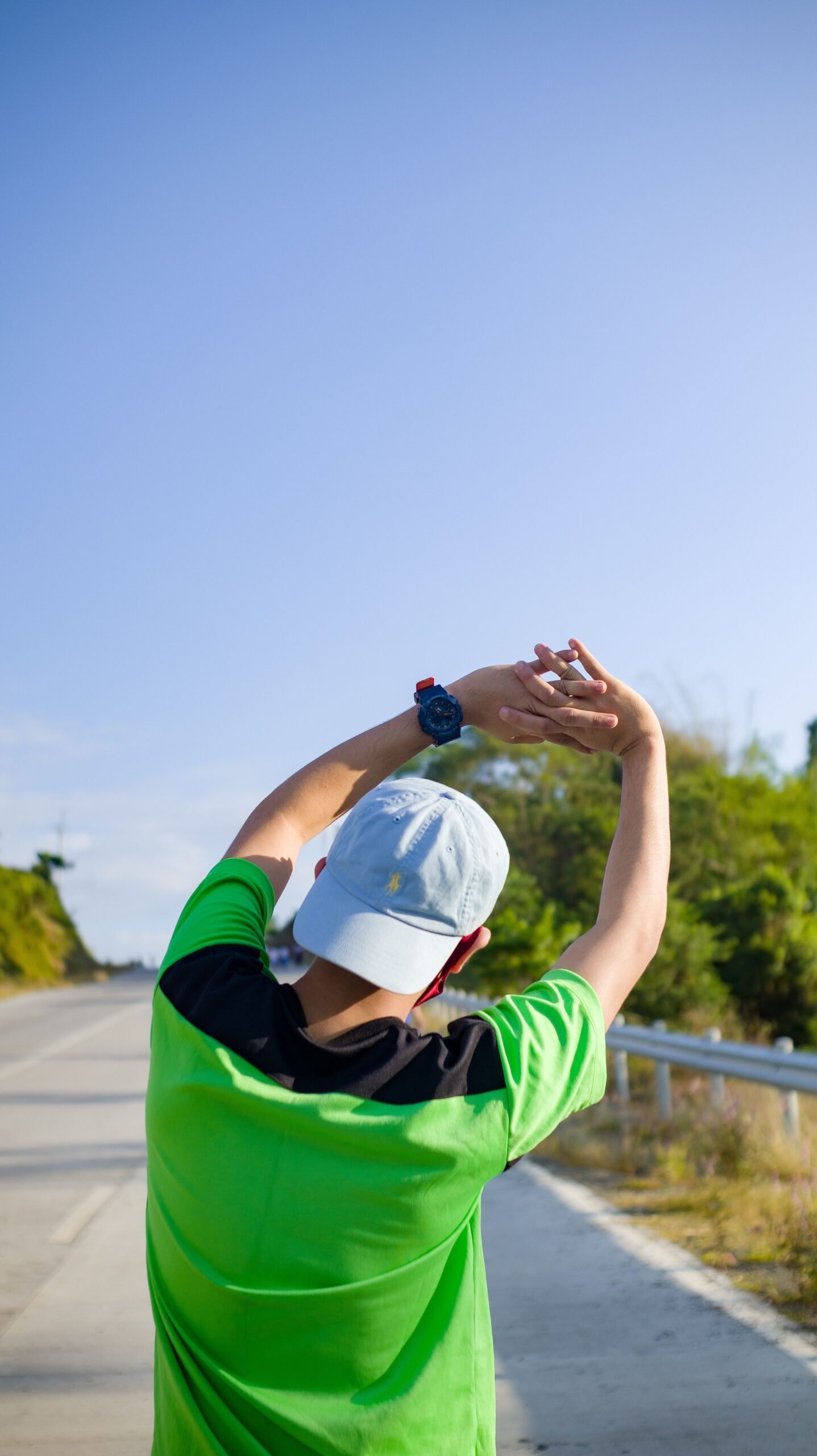 Runner stretching arms overhead before an outdoor training session