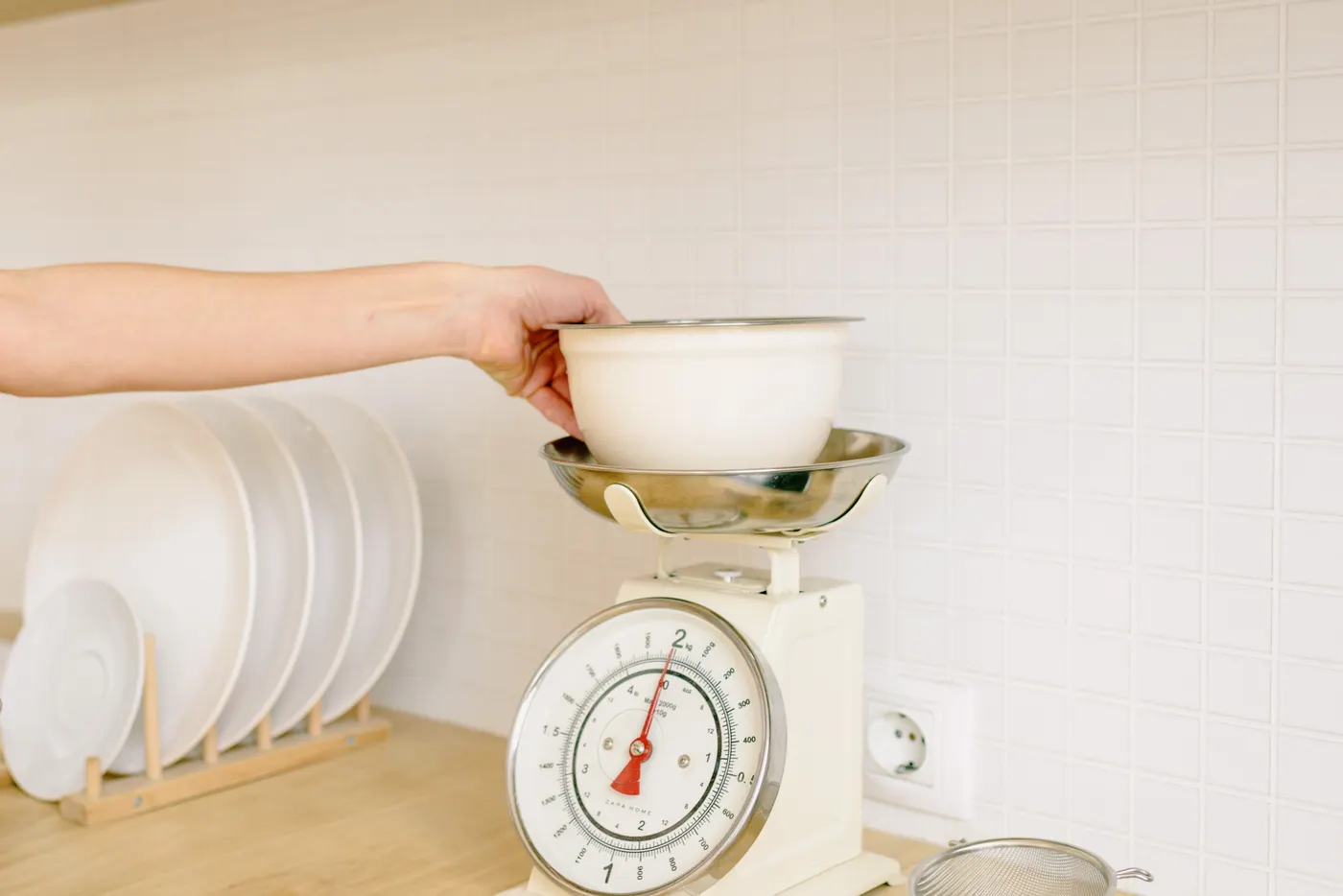 Person weighing food ingredients while planning a meal
