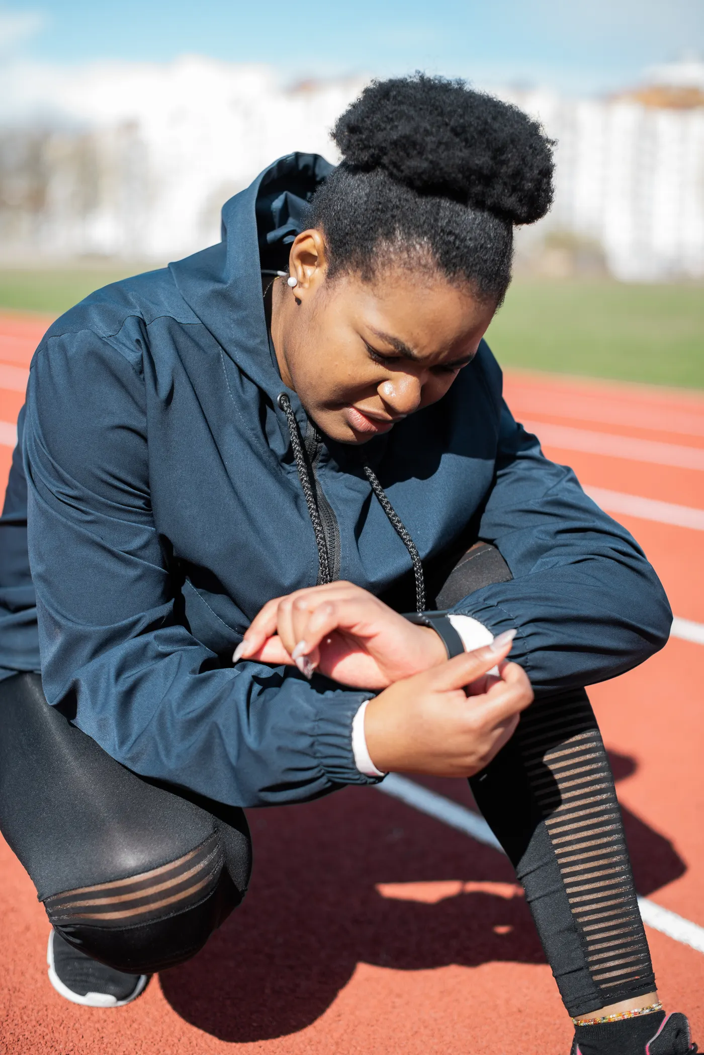 Woman checking a sports watch during a running-track workout