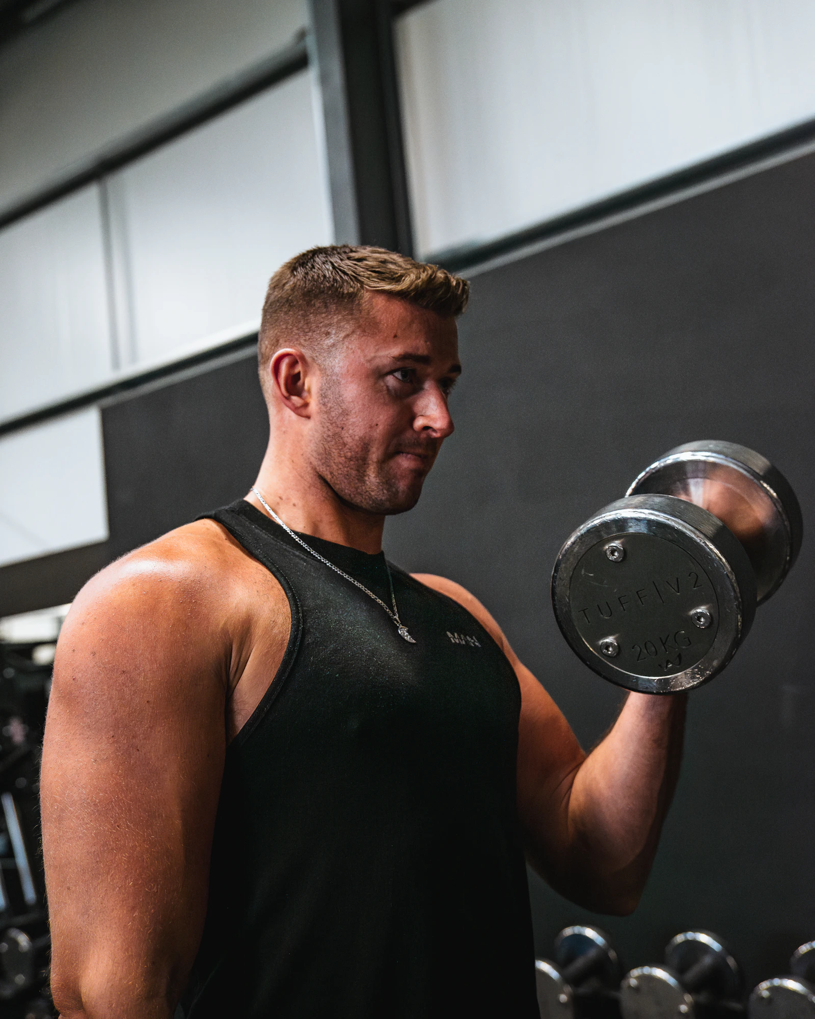 Man performing a dumbbell biceps curl during gym training