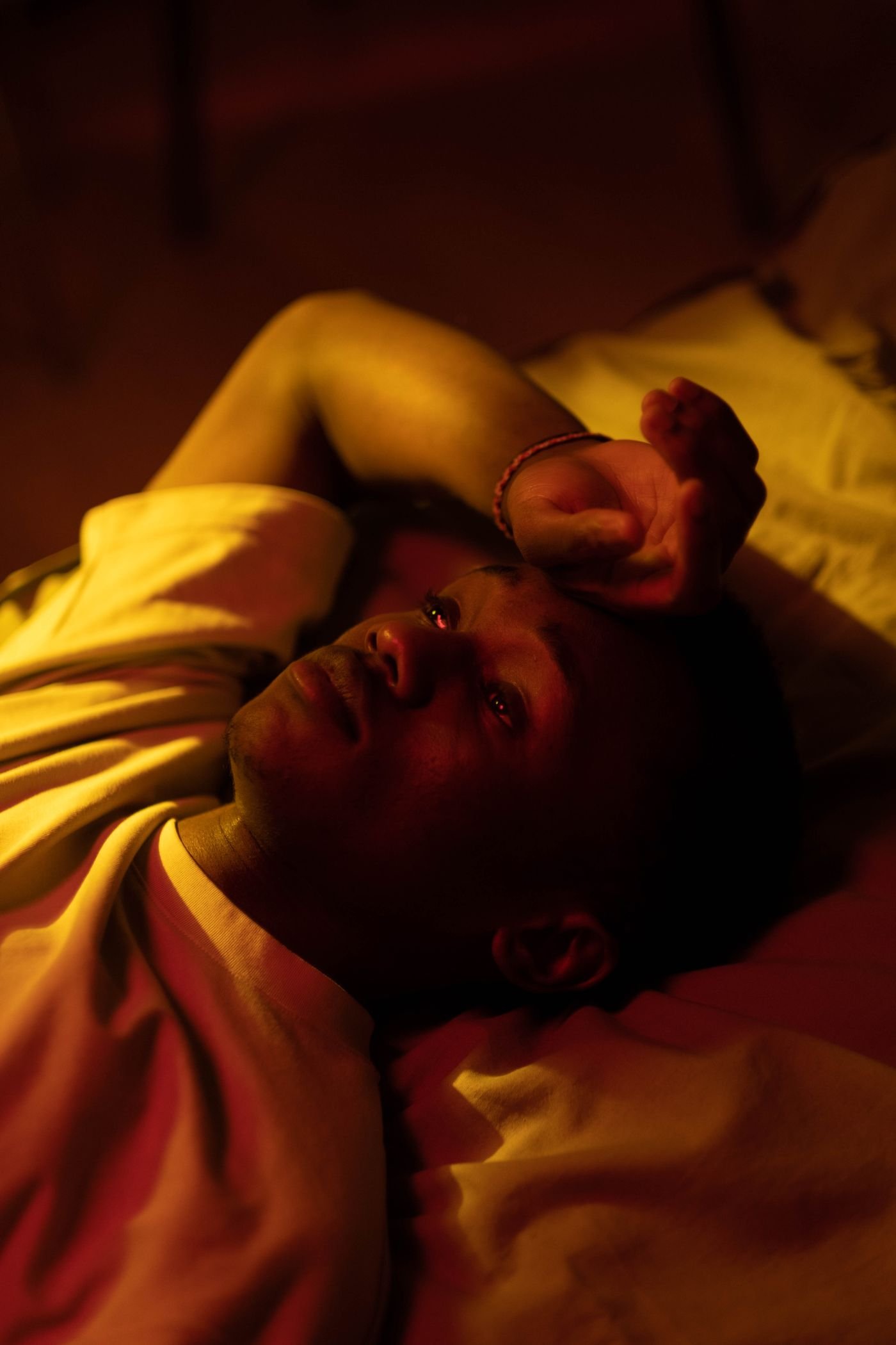 Man resting in a dim bedroom at night
