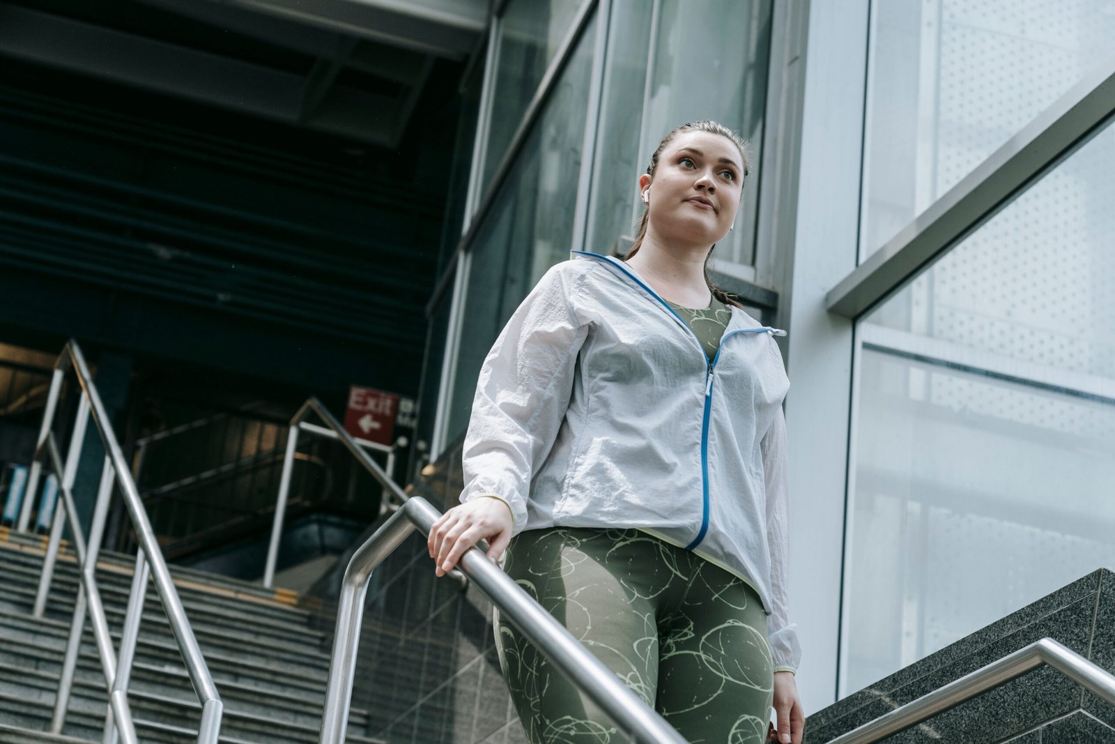 Woman in athletic clothing walking on an urban staircase