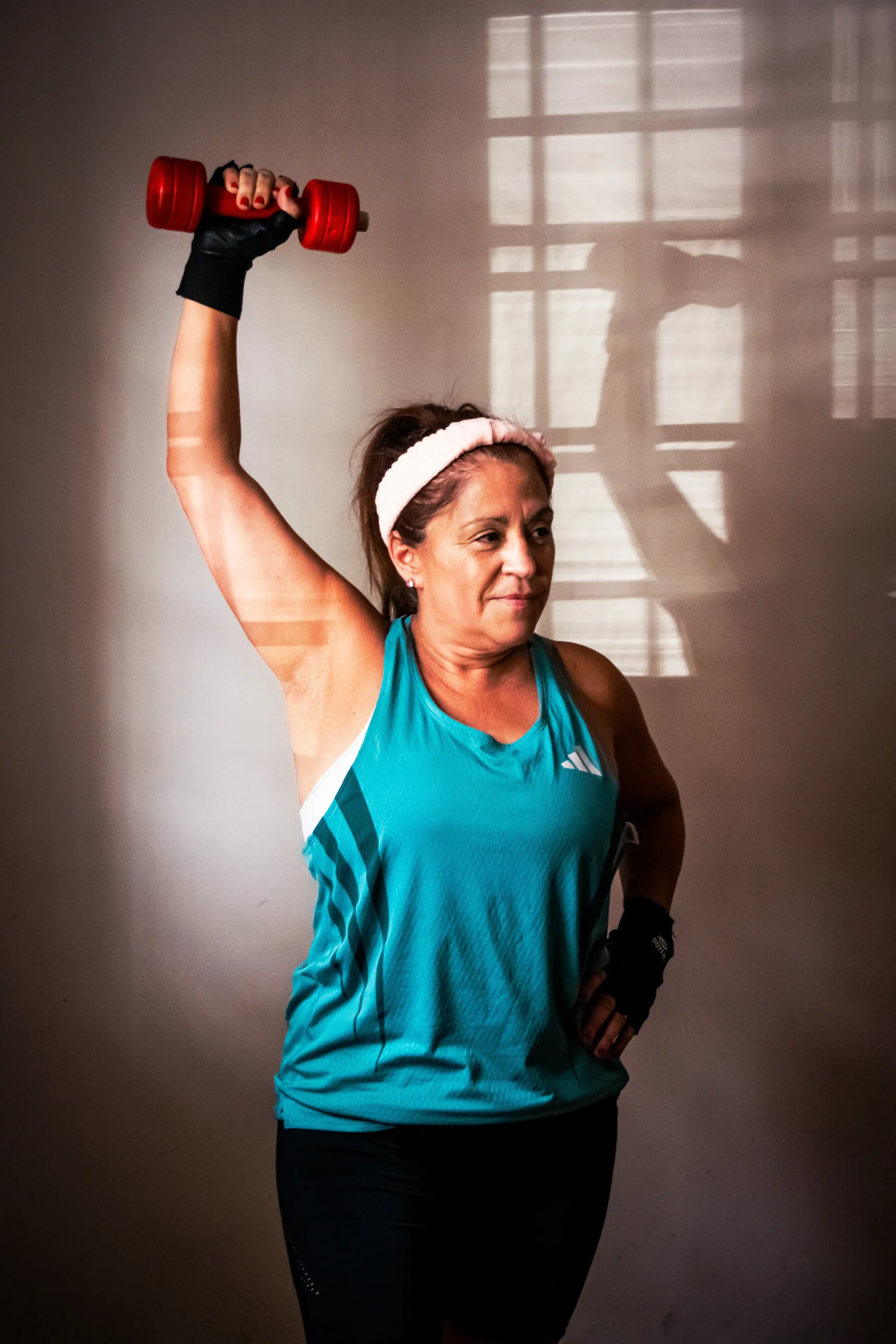 Senior woman lifting a dumbbell during an indoor strength exercise