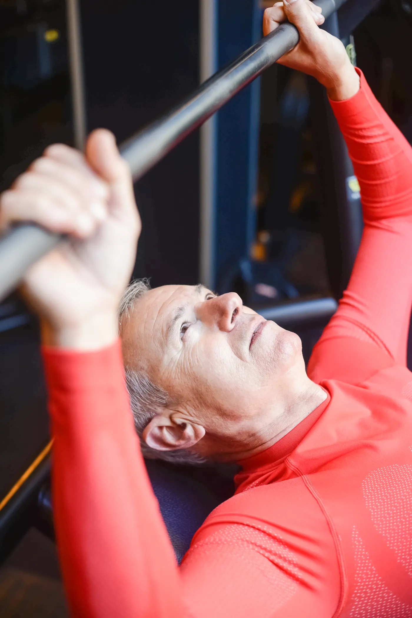 Man performing a barbell exercise in a gym