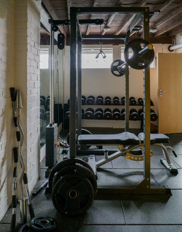 Compact home gym with a bench, free weights and strength-training equipment