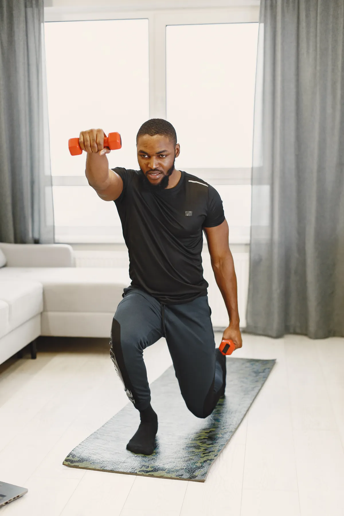 Man doing a controlled home lunge with light dumbbells