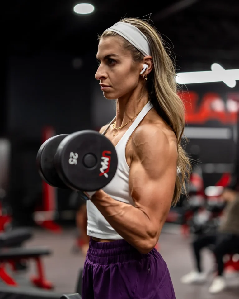 Woman performing a dumbbell curl during a gym workout