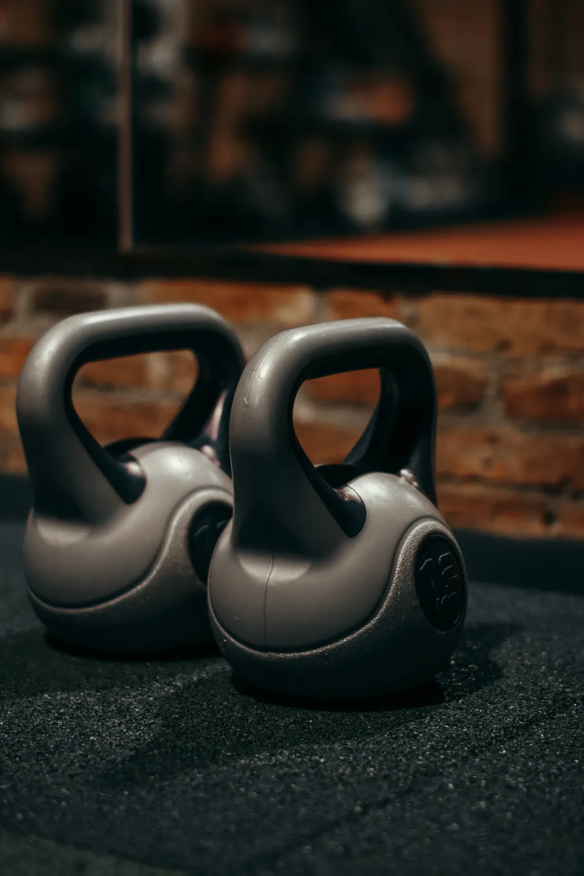 Pair of kettlebells on a gym floor ready for a mixed-modality workout