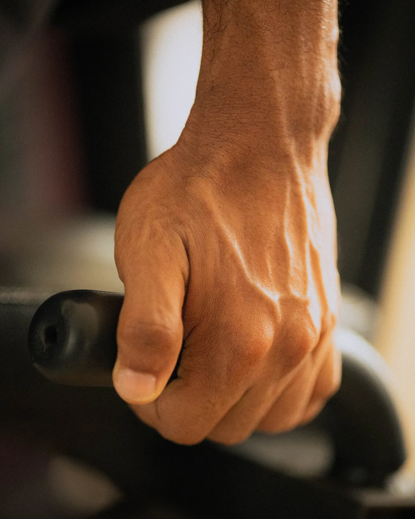 Close-up of a hand firmly gripping strength equipment