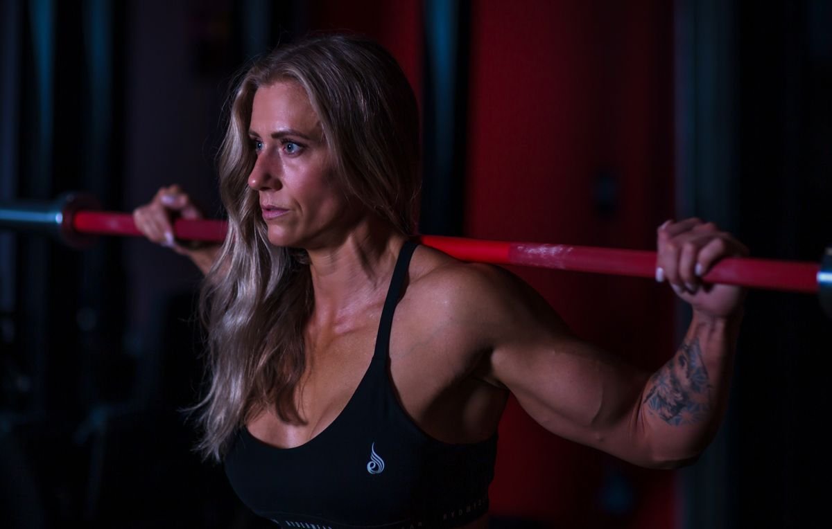 Strong woman lifting a barbell in a gym