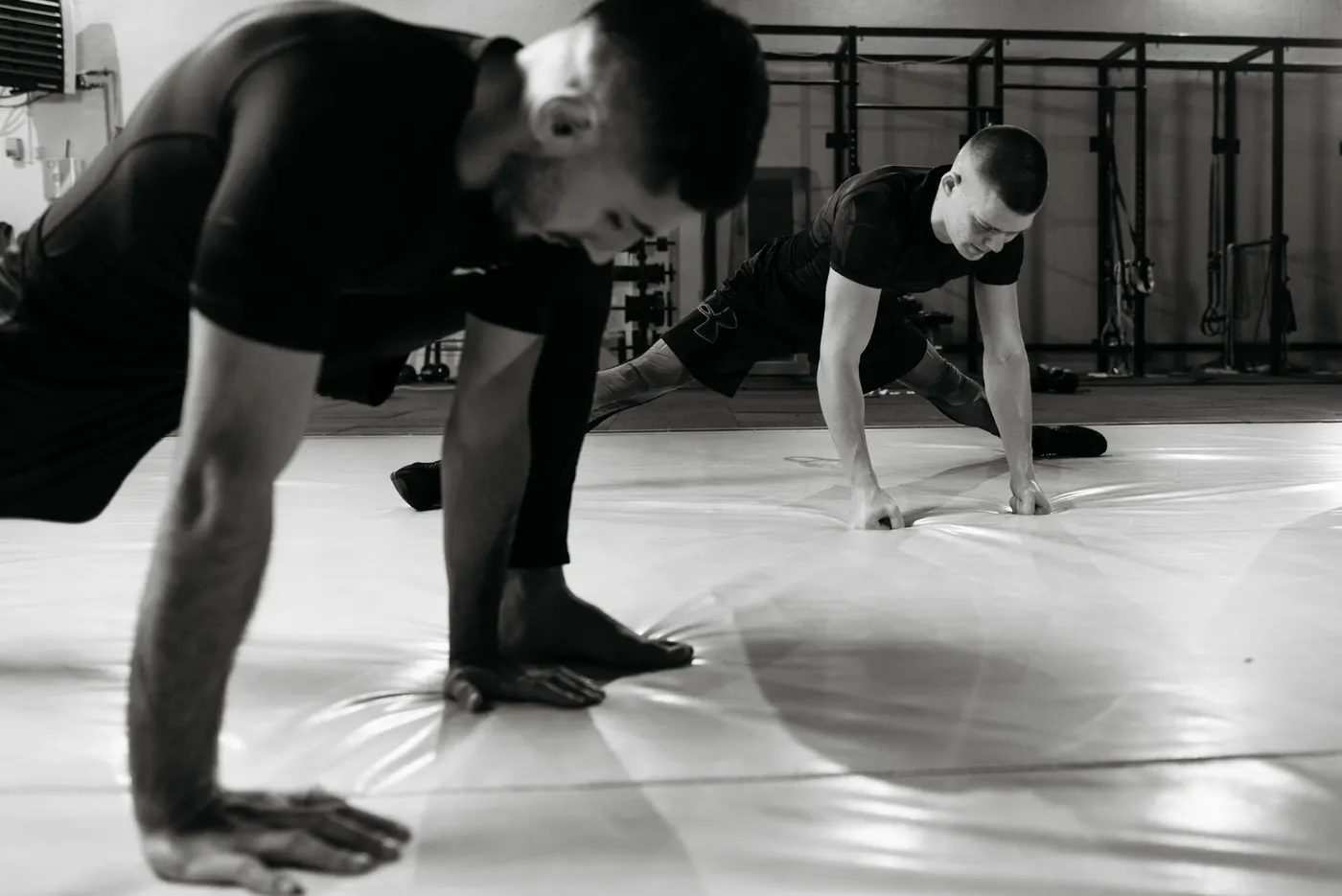 Two men stretching in a gym after exercise