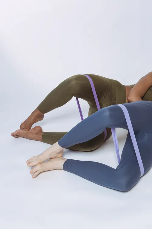Two athletes exercising with resistance bands on a studio floor