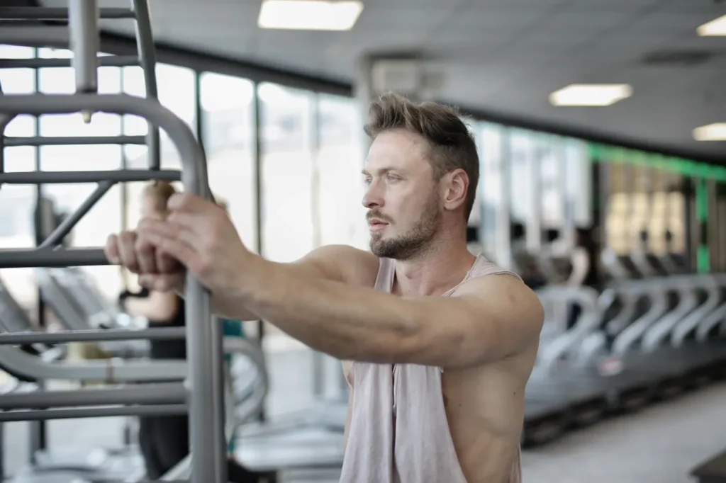 Strength athlete pausing at a gym machine between workouts