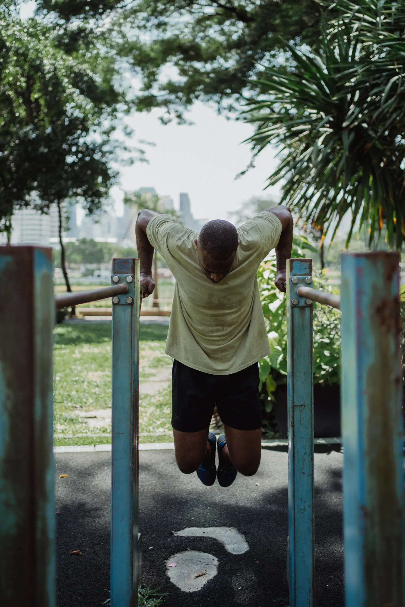 Man lowering into a dip on parallel bars