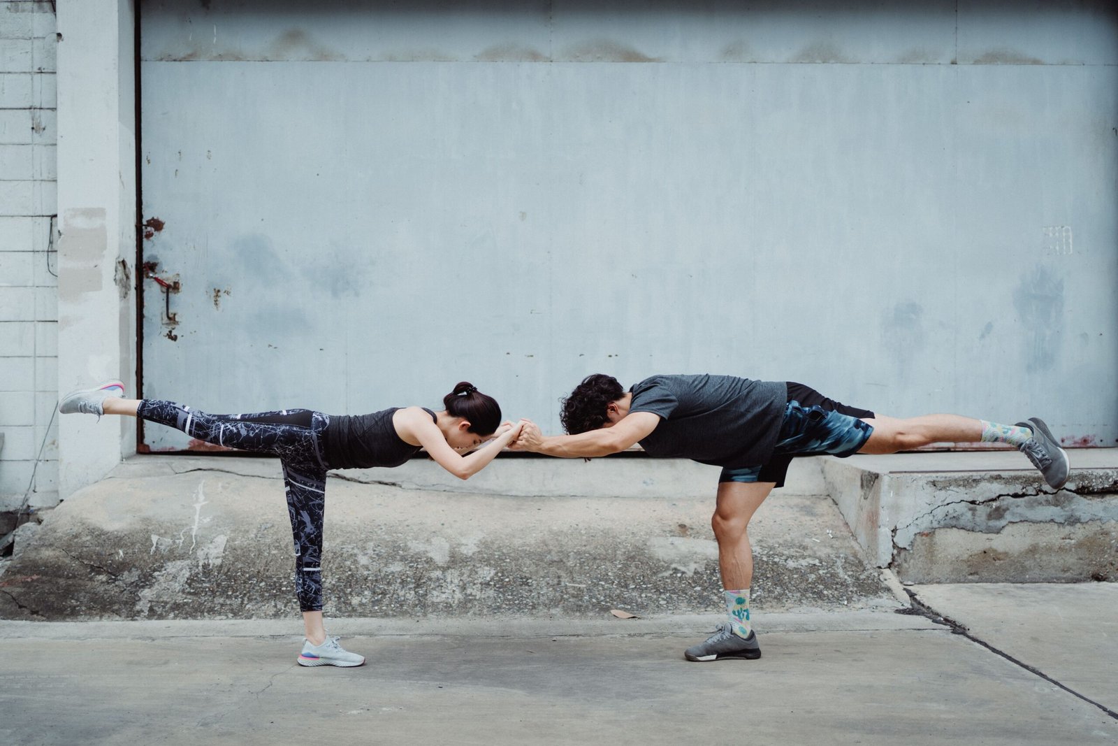 Two athletes practicing single-leg balance together outdoors