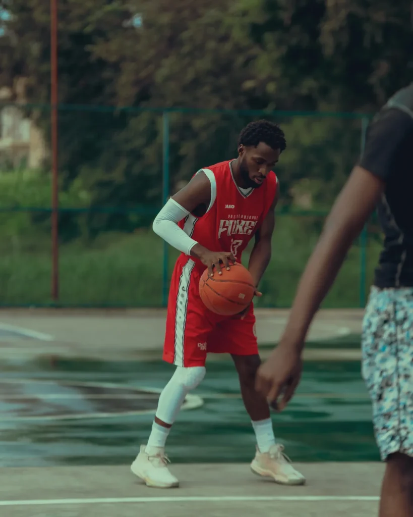Basketball player practicing dribbling on an outdoor court