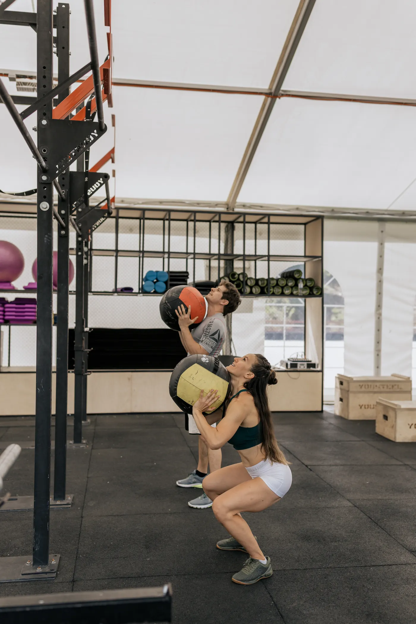 Training partners working with medicine balls in a gym