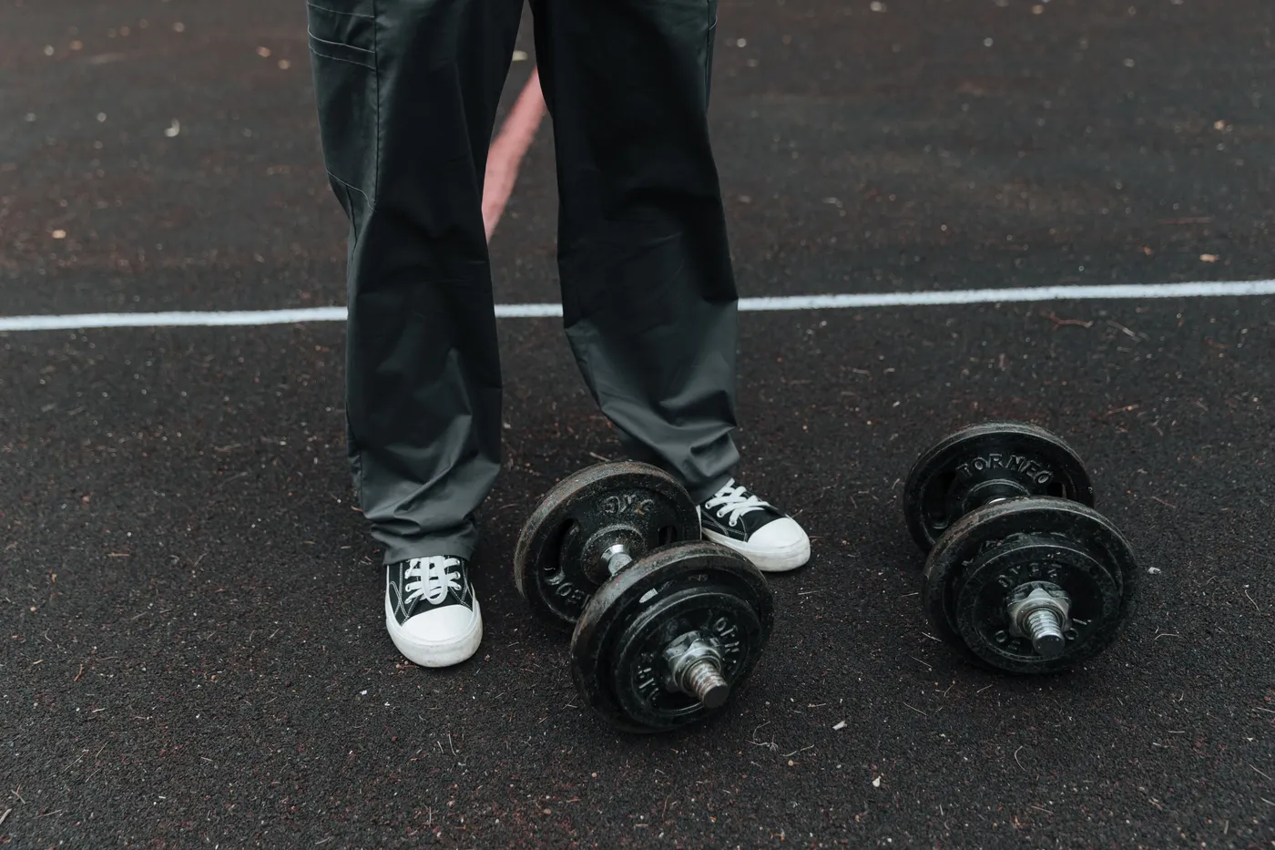 Dumbbells beside an athlete's shoes before a training session