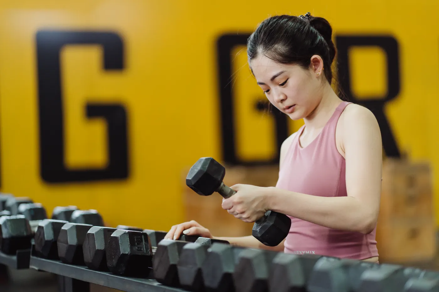 Woman lifting a dumbbell in a gym during resistance training