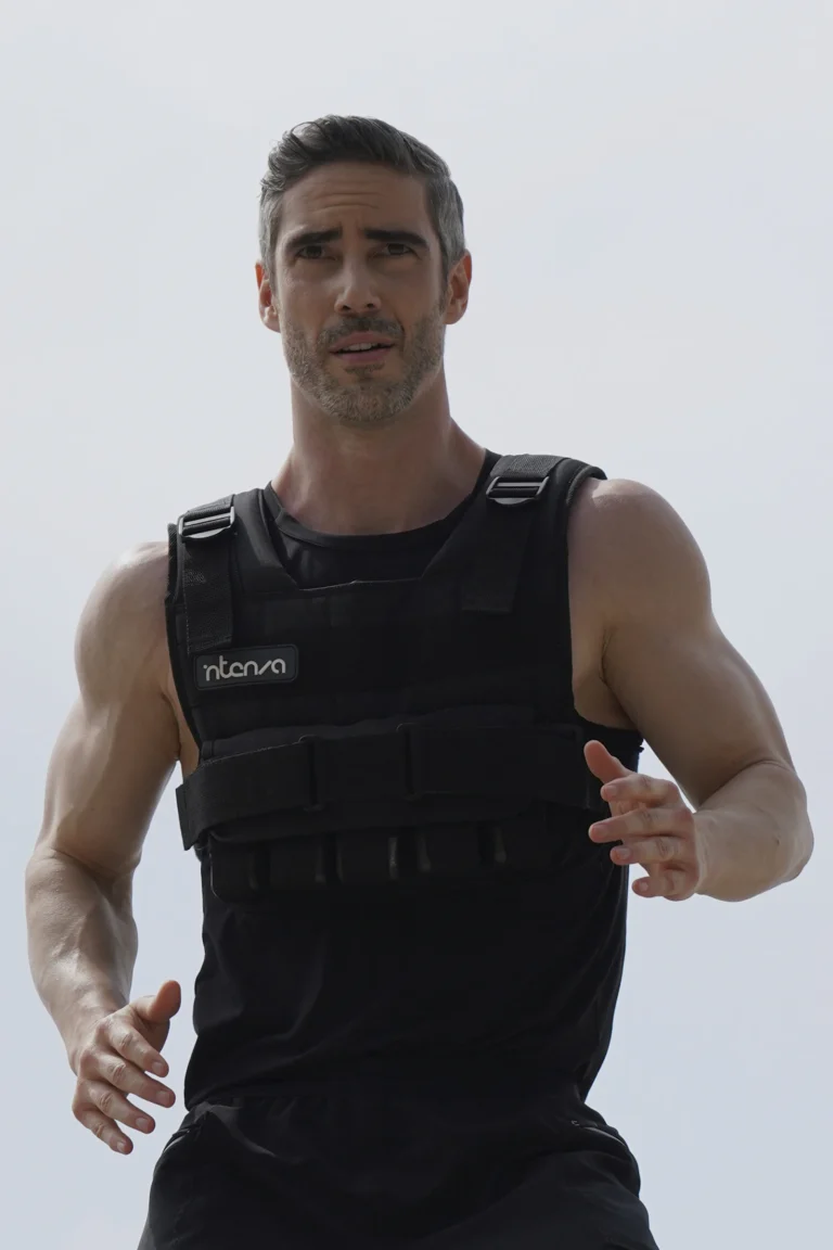 Athlete wearing a black weighted vest during outdoor running training