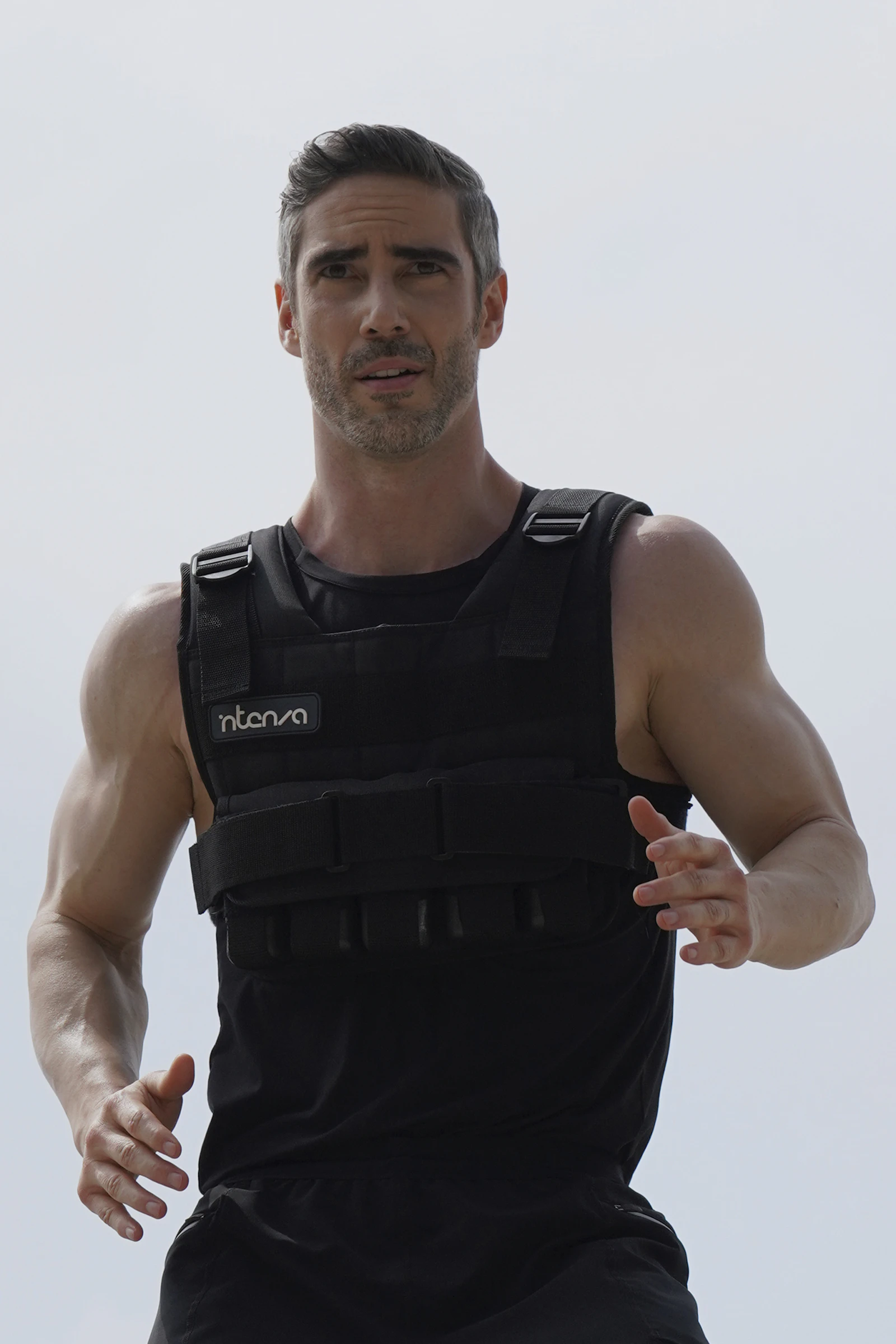 Athlete wearing a black weighted vest during outdoor running training