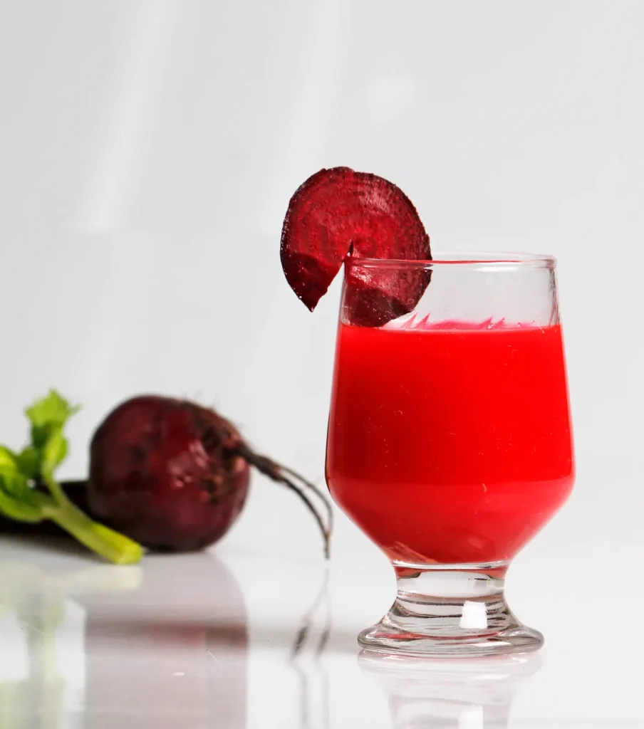 Glass of deep red beetroot juice with a beet slice